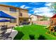 Expansive backyard features an artificial grass lawn, covered patio, and outdoor entertaining space at 16565 W Garfield St, Goodyear, AZ 85338