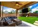 Entertainer's backyard with covered patio, outdoor seating, and a spacious artificial grass lawn at 16565 W Garfield St, Goodyear, AZ 85338