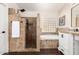 Bathroom featuring a walk-in shower with stacked-tile, soaking tub, and a dark stained floors at 16565 W Garfield St, Goodyear, AZ 85338