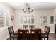 Dining area with shuttered windows and a modern chandelier above the wood dining table at 16565 W Garfield St, Goodyear, AZ 85338