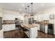Bright kitchen featuring white cabinetry, granite countertops, stainless steel appliances, and a functional center island at 16565 W Garfield St, Goodyear, AZ 85338