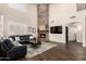 Inviting living room featuring a stone fireplace, dark wood floors, and plush leather seating at 16565 W Garfield St, Goodyear, AZ 85338
