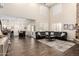 Open-concept living room with high ceilings, a stone fireplace, and a large black leather sofa at 16565 W Garfield St, Goodyear, AZ 85338