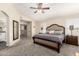 Spacious main bedroom featuring a large bed, neutral tones, a ceiling fan, and an en suite bathroom at 16565 W Garfield St, Goodyear, AZ 85338