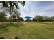 Community playground with shade, lush grass, and mature trees on a sunny day at 16565 W Garfield St, Goodyear, AZ 85338