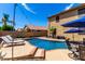 Inviting backyard pool with lounge chairs, manicured landscaping, and clear blue water on a sunny day at 16565 W Garfield St, Goodyear, AZ 85338