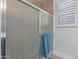 Bathroom shower with sliding doors, window with shutters, tile surround and tile floor at 1723 W Mercury Way, Chandler, AZ 85224