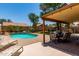Back yard features a private pool, covered patio with table, chairs and lights, with lounge chairs at 1723 W Mercury Way, Chandler, AZ 85224