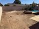 Spacious, but somewhat barren back yard with an in-ground pool in the background at 17371 N 86Th Ave, Peoria, AZ 85382