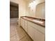 Bathroom with a double sink vanity, granite countertop, white cabinets, and tiled floors at 17371 N 86Th Ave, Peoria, AZ 85382