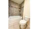 Bathroom with a tile-surround tub and shower, plus a toilet at 17371 N 86Th Ave, Peoria, AZ 85382