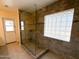 Beautiful bathroom featuring a tiled walk-in shower with glass door and privacy glass block window at 17371 N 86Th Ave, Peoria, AZ 85382