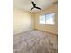 Bedroom with neutral carpet, ceiling fan, closet, window, and light paint at 17371 N 86Th Ave, Peoria, AZ 85382