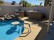 Backyard pool featuring in-pool seating, rock features and an outdoor kitchen area at 17371 N 86Th Ave, Peoria, AZ 85382