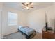 Cozy bedroom with carpet, a ceiling fan, a window, and furnishings including a bed and a dresser at 17851 N Mughetto Dr, Maricopa, AZ 85138