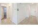 Inviting hallway featuring tiled floors, a smart thermostat, and access to multiple rooms at 17851 N Mughetto Dr, Maricopa, AZ 85138