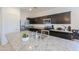 This kitchen boasts stainless steel appliances, granite countertops, and dark cabinets, creating a modern and stylish space at 17851 N Mughetto Dr, Maricopa, AZ 85138