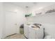 Functional laundry room with modern washer and dryer, storage shelves, and a convenient door at 17851 N Mughetto Dr, Maricopa, AZ 85138