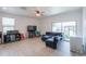 Bright living room with tile floors, a ceiling fan, and a large glass sliding door to the backyard at 17851 N Mughetto Dr, Maricopa, AZ 85138