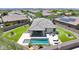 Aerial view of the home featuring a backyard oasis with a pool, spa, and covered patio, surrounded by lush landscaping at 18000 W Thistle Landing Dr, Goodyear, AZ 85338