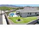 Beautiful backyard with a pool, covered patio, desert landscaping, and mountain views at 18000 W Thistle Landing Dr, Goodyear, AZ 85338
