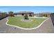 Lush backyard with manicured desert landscaping, sparkling pool, and a covered patio with outdoor furniture at 18000 W Thistle Landing Dr, Goodyear, AZ 85338