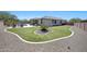 Beautiful backyard with a pool, artificial turf, covered patio and desert landscaping at 18000 W Thistle Landing Dr, Goodyear, AZ 85338
