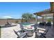 Relaxing backyard with a cozy fire pit, sparkling pool, covered patio and comfortable lounge chairs at 18000 W Thistle Landing Dr, Goodyear, AZ 85338