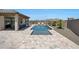 Inviting backyard features a pool, covered patio with seating area, and low-maintenance desert landscaping at 18000 W Thistle Landing Dr, Goodyear, AZ 85338