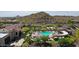 An aerial view of the community pool area complete with shaded seating and well-kept landscaping at 18000 W Thistle Landing Dr, Goodyear, AZ 85338