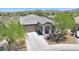 Front elevation view of this beautiful home with a well-maintained yard and desert landscaping at 18000 W Thistle Landing Dr, Goodyear, AZ 85338
