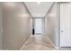 Inviting hallway with neutral paint and tile floors, leading to the front door at 18000 W Thistle Landing Dr, Goodyear, AZ 85338
