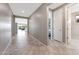 Well-lit hallway showcasing neutral walls and tile flooring, leading to various rooms at 18000 W Thistle Landing Dr, Goodyear, AZ 85338