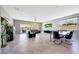 Open-concept living room with tile flooring, large windows, and a view of the backyard and pool area at 18000 W Thistle Landing Dr, Goodyear, AZ 85338