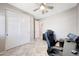Bright home office with a ceiling fan, closet, and black desk with computer at 18000 W Thistle Landing Dr, Goodyear, AZ 85338