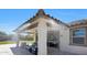Comfortable covered patio includes misting system, fan, stylish outdoor furniture, and travertine tile at 18000 W Thistle Landing Dr, Goodyear, AZ 85338