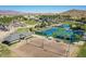 Aerial view of well-maintained community tennis courts with mountain views in the background at 18000 W Thistle Landing Dr, Goodyear, AZ 85338