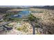 This is an aerial view of a community with a lake, single Gathering homes, tennis courts, and a park at 18425 W Santa Irene Dr, Goodyear, AZ 85338