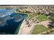 This is an aerial view of a lake, beach, park, and single Gathering homes in a planned community at 18425 W Santa Irene Dr, Goodyear, AZ 85338