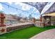 A gorgeous backyard patio with decorative water feature, lush turf and decorative pergola at 18425 W Santa Irene Dr, Goodyear, AZ 85338
