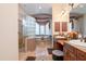 Bright bathroom featuring double sinks, a glass block shower, and a soaking tub under a window at 18425 W Santa Irene Dr, Goodyear, AZ 85338