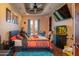 Cozy bedroom with a ceiling fan, french doors, a television, and an aquarium at 18425 W Santa Irene Dr, Goodyear, AZ 85338