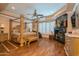 Spacious bedroom with hardwood floors, a fireplace, and a canopy bed at 18425 W Santa Irene Dr, Goodyear, AZ 85338