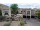 Elegant stucco home with stone accents, arched entryway, three-car garage, and desert landscaping at 18425 W Santa Irene Dr, Goodyear, AZ 85338