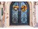 Close-up of the arched double front doors decorated with seasonal fall wreaths at 18425 W Santa Irene Dr, Goodyear, AZ 85338