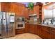 Close up of the kitchen showcasing stainless steel appliances, custom cabinetry, and granite countertops at 18425 W Santa Irene Dr, Goodyear, AZ 85338