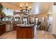 Open concept kitchen features a center island with sink, pendant lighting, and views to the dining and living areas at 18425 W Santa Irene Dr, Goodyear, AZ 85338