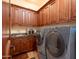 Functional laundry room with front-loading washer and dryer, custom cabinetry, and a utility sink at 18425 W Santa Irene Dr, Goodyear, AZ 85338
