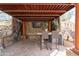 Relaxing outdoor space with stacked stone walls, decorative columns, and a mounted TV at 18425 W Santa Irene Dr, Goodyear, AZ 85338