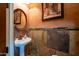 Stylish powder room with textured walls, stone accents, and a pedestal sink at 18425 W Santa Irene Dr, Goodyear, AZ 85338